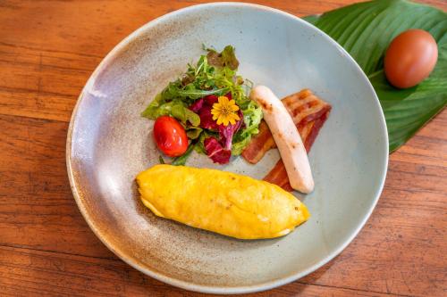 een bord eten met ontbijtproducten op tafel bij The Riverfront Reserve in Pai