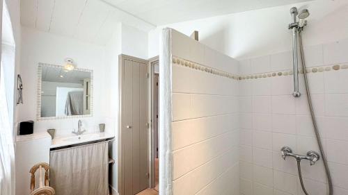 a white bathroom with a shower and a sink at Charmante maison à deux pas de la plage in Les Portes