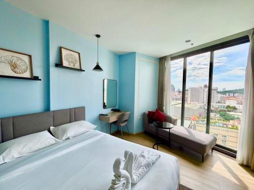En eller flere senge i et værelse på EDGE Central Pattaya Luxury Condo