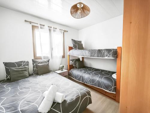 a bedroom with two beds and a bunk bed at Appartement confortable avec parking et terrasse in Leucate-Plage