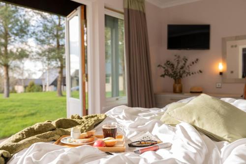 a bed with a tray of food and drinks on it at Landal Hexham Lodges in Slaley