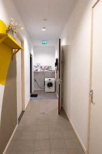 a hallway with a washing machine in a room at Hoeve Linnerveld Trekkerstent in Sint Odiliënberg