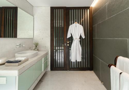 a bathroom with a robe hanging on the door at LohonoStays Villa Gomti in Lonavala