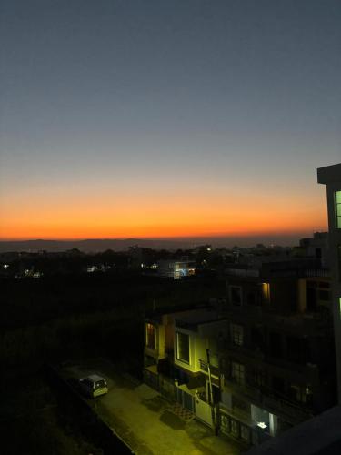 a view of a sunset from a building at Shivoham Retreat in Dehradun