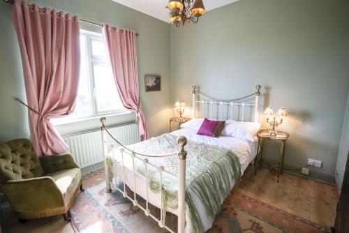 een slaapkamer met een bed, een stoel en een raam bij Halyon Village in Greencastle