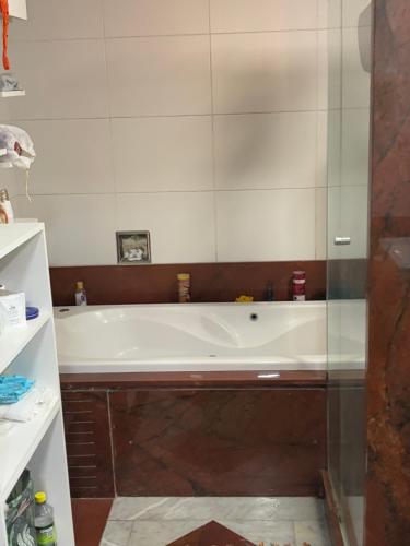 a bath tub in a bathroom with a glass wall at Estúdio dos sonhos in Rio de Janeiro