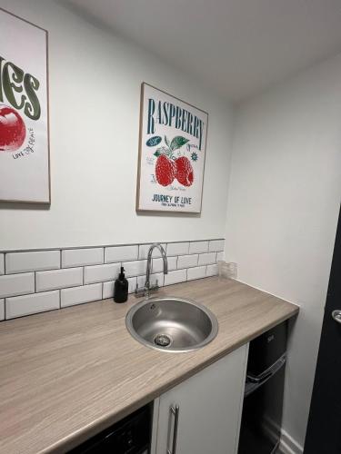 a bathroom with a sink and a sign on the wall at Modern Studio Central WV1 Appt 4 in Wolverhampton