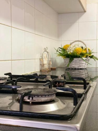 a kitchen stove with a vase of flowers on it at Guildford room near Cafe and Train in Guildford