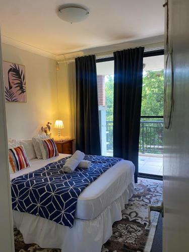 a bedroom with a bed and a large window at Guildford room near Cafe and Train in Guildford