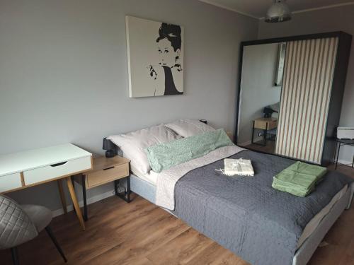una piccola camera da letto con un letto e una scrivania di Jagiellonskie a Poznań