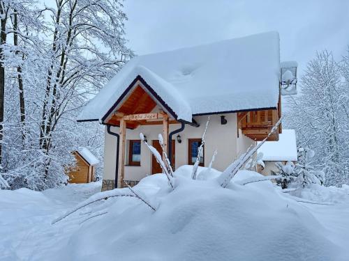 a snow covered cabin with a pile of snow at Oleksowiczówka in Zborowice