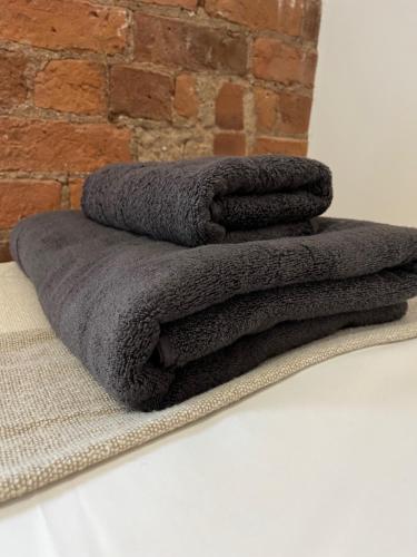 a pile of grey towels sitting on a table at Urban City Centre Apartment 1 Private Parking in Hull