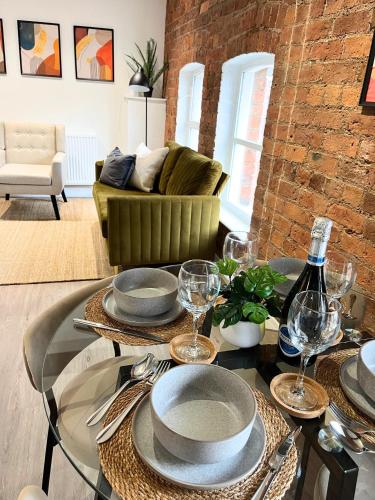 a dining room with a table with plates and wine glasses at Urban City Centre Apartment 1 Private Parking in Hull