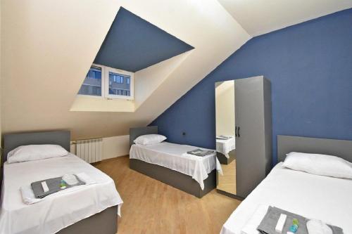 a room with two beds and a blue wall at tumanyan 38 guest hause in Yerevan