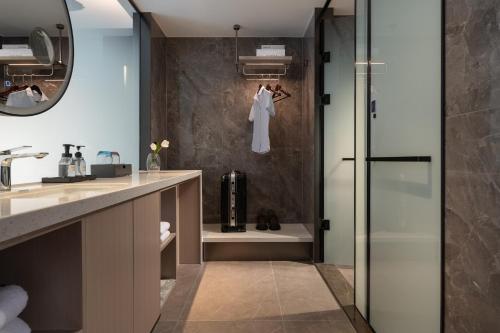 Huanman Hotel Changsha Wuyi Square South Gate Metro Station Branch في تشانغشا: حمام مزود بدش ومغسلة