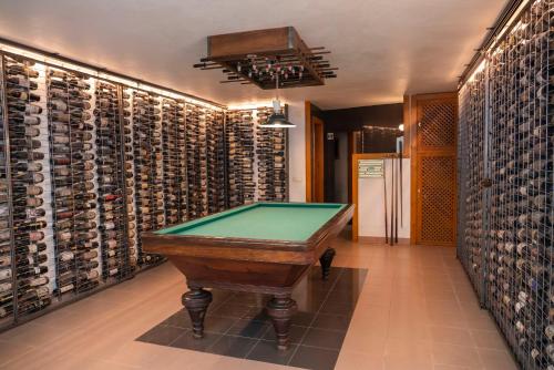 a room with a pool table in front of a wine cellar at Casa Do Foral in Rio Maior