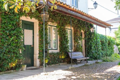 a bench sitting in front of a building with ivy at Casa Do Foral in Rio Maior