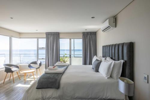 una camera da letto con un letto grande con vista sull'oceano di Ocean View Properties - Apartment 701 a Città del Capo