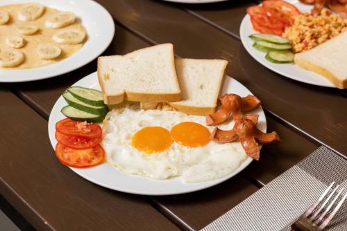 drie borden met eieren, brood en groenten op een tafel bij Cat Ba hotel & apartment in Hang Suối