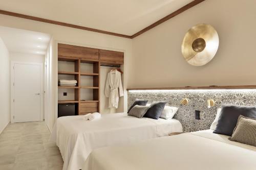 zwei Betten in einem Zimmer mit weißen Wänden in der Unterkunft Hotel Best Village Chipiona in Costa Ballena