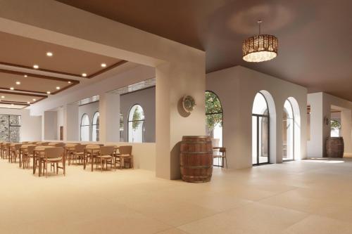 een grote kamer met tafels en stoelen en een vat bij Hotel Best Village Chipiona in Costa Ballena