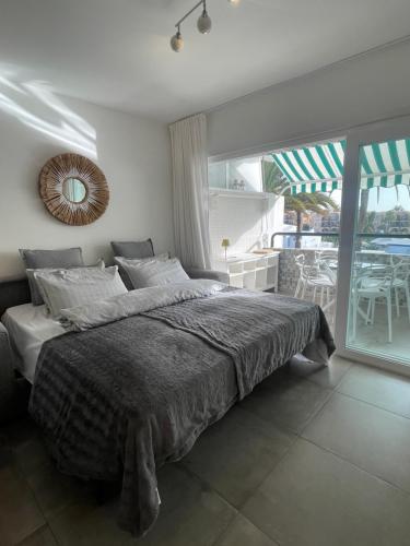 a bedroom with a large bed and a balcony at Apartment Palm Tree View in Maspalomas