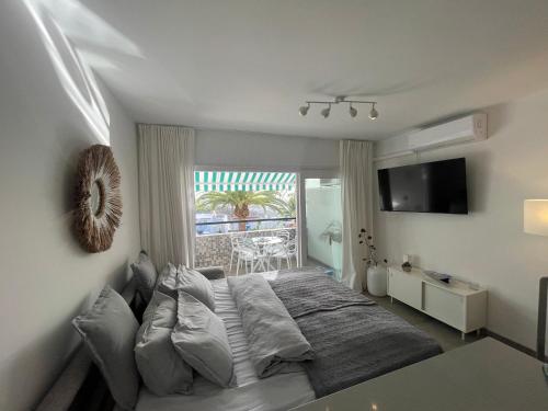 a bedroom with a large bed and a window at Apartment Palm Tree View in Maspalomas