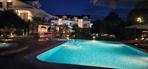 a swimming pool in front of a building at night at Hotel Resort Comfort in Ulcinj