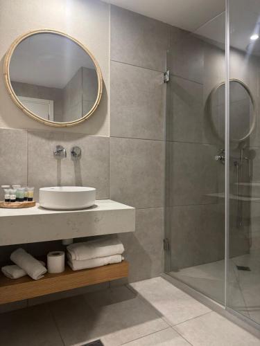 a bathroom with a shower and a sink and a mirror at מלון המושבה כפר תבור in Kefar Tavor