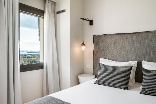 a bedroom with a large bed with a window at Ermioni Countryside Residence by Konnect, Agios Markos in Ágios Márkos