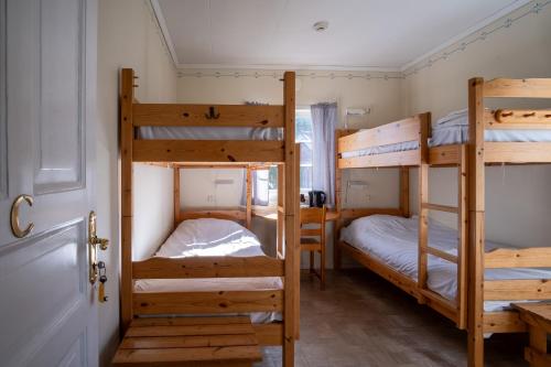 two bunk beds in a room with a door at Sunne Hembygdsgård B&B in Sunne