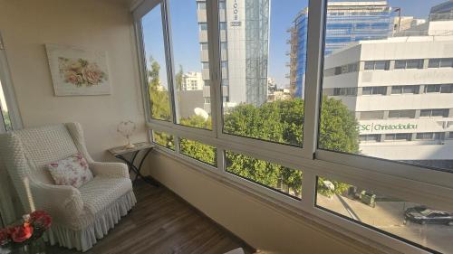 Zimmer mit einem Stuhl und einem Fenster mit Aussicht in der Unterkunft STAY Vintage Central Suite in Nikosia