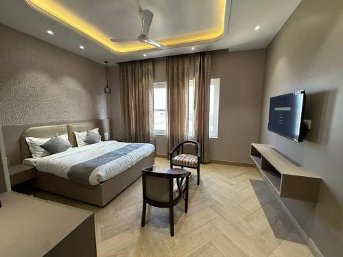 ein Hotelzimmer mit einem Bett und einem Flachbildfernseher in der Unterkunft Duggar Haveli Hotel & Restaurant in Jammu