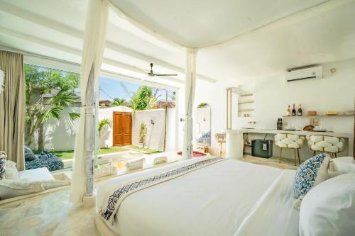a bedroom with a large white bed and a fireplace at Mare 1BR Romantic Villa, 5 Min to Thomas Beach in Uluwatu