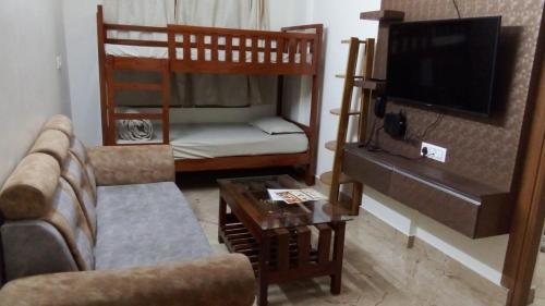 a living room with two bunk beds and a couch at Kamadhenu Residency Homestay & Service Apartment Coorg Madikeri in Madikeri