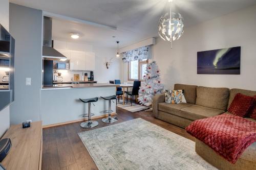 a living room with a couch and a christmas tree at Matti's Charming Studio in Rovaniemi