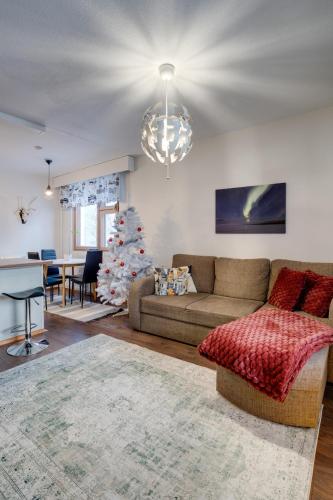 a living room with a couch and a christmas tree at Matti's Charming Studio in Rovaniemi