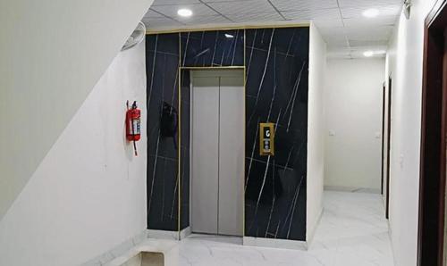 Un pasillo con una pared en blanco y negro y una boca de incendios. en FabHotel Kalka Residency, en Nueva Delhi