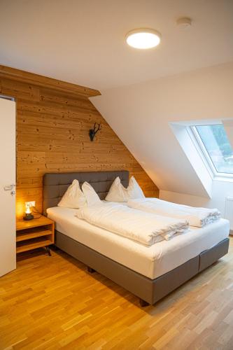 a large bed in a room with a window at Dorfplatzl Suite in Hohentauern