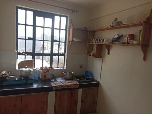 a kitchen with a counter top and a window at Jay homes in Kakamega