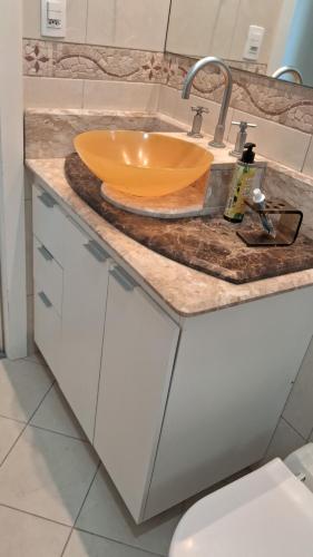 Itapema beira mar في ايتابيما: حمام مع حوض مع وعاء عليه