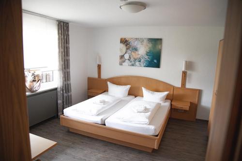 a bedroom with a bed with white sheets at Landgasthof Freiberger in Schnabelwaid