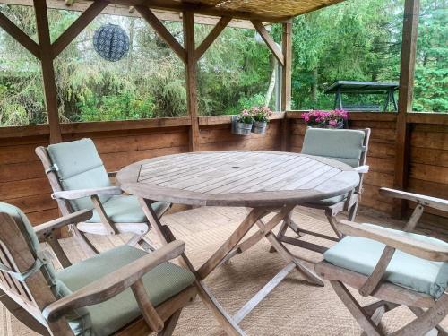 a wooden table and chairs on a screened porch at 6 person holiday home in Fårvang in Fårvang