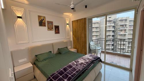 a bedroom with a bed and a large window at Krishna Heights in Karnal