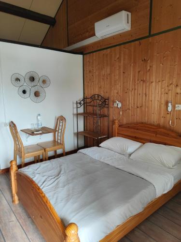 a bedroom with a large bed with a table and chairs at auberge la fermette in Le Tampon