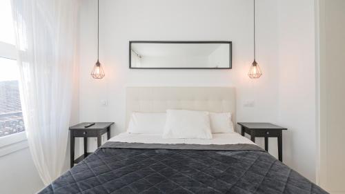 a bedroom with a bed with two night stands and two lamps at San Torcuato VIII by Toledo AP in Toledo