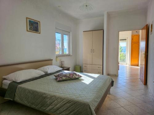 a bedroom with a large bed and a hallway at Apartments Giran in Lokva Rogoznica