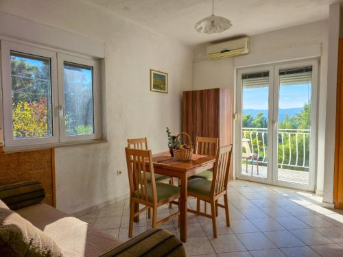 a dining room with a table and chairs and a balcony at Apartments Giran in Lokva Rogoznica