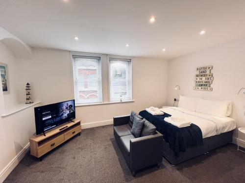 a bedroom with a large bed and a television at Southside Street Apartments in Plymouth