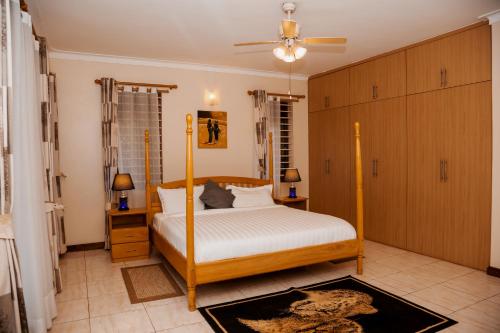 a bedroom with a bed and a ceiling fan at Calm Suites Kampala in Kampala